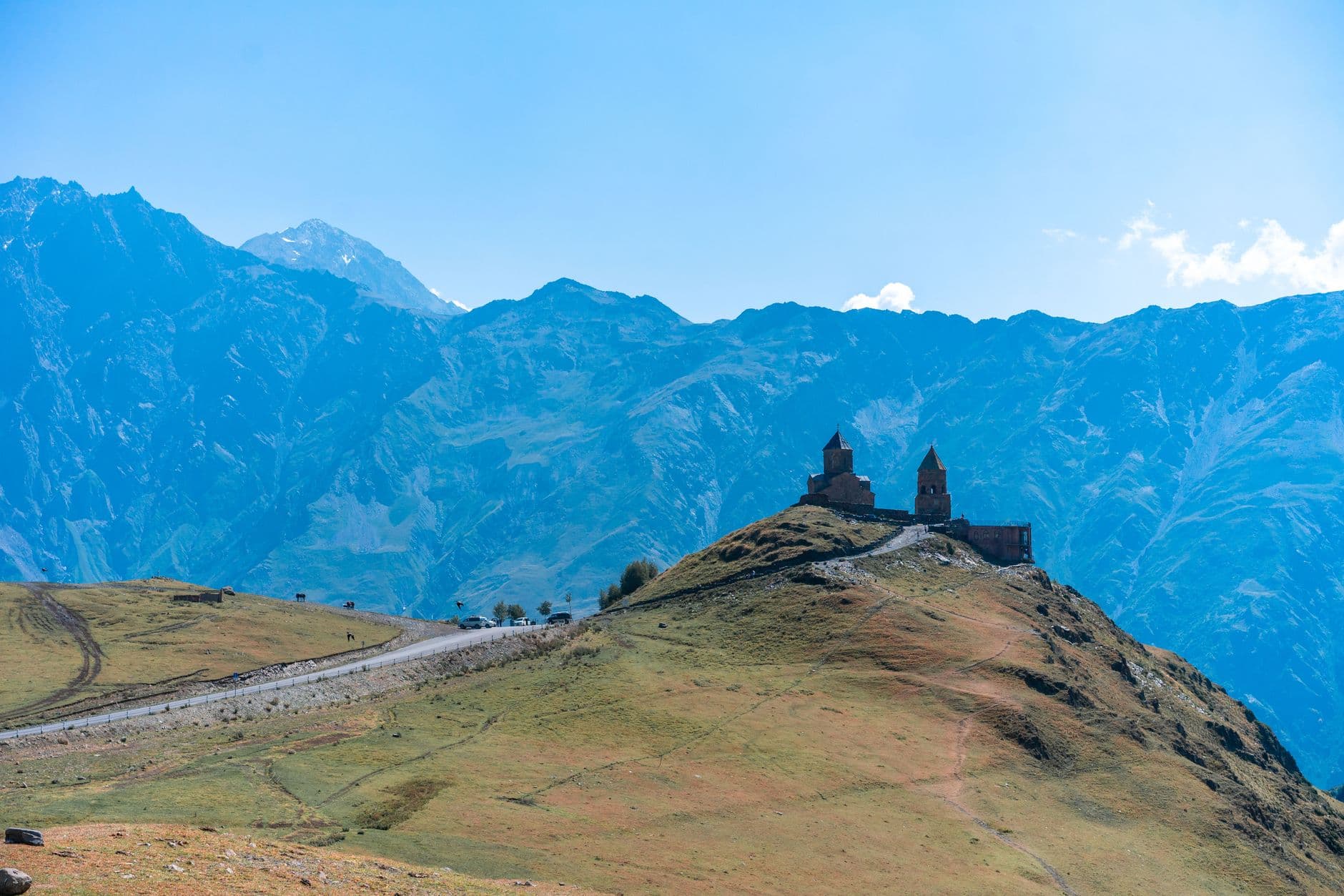Gergeti Trinity Church against the backdrop of the Caucasus Mountains on a sunny day